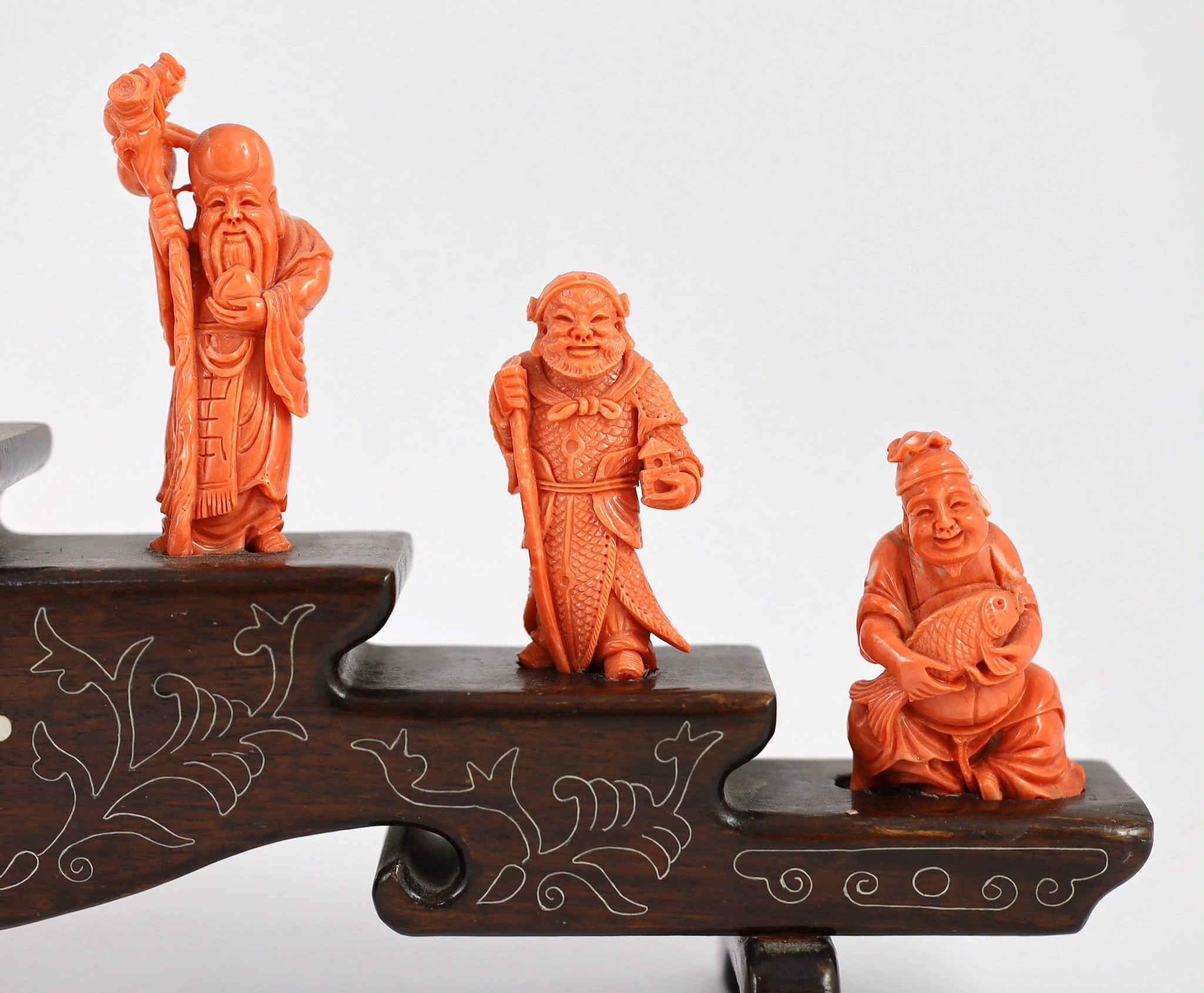 A Chinese or Japanese set of seven coral figures of immortals, 43cm wide, figures 4 to 8cm high